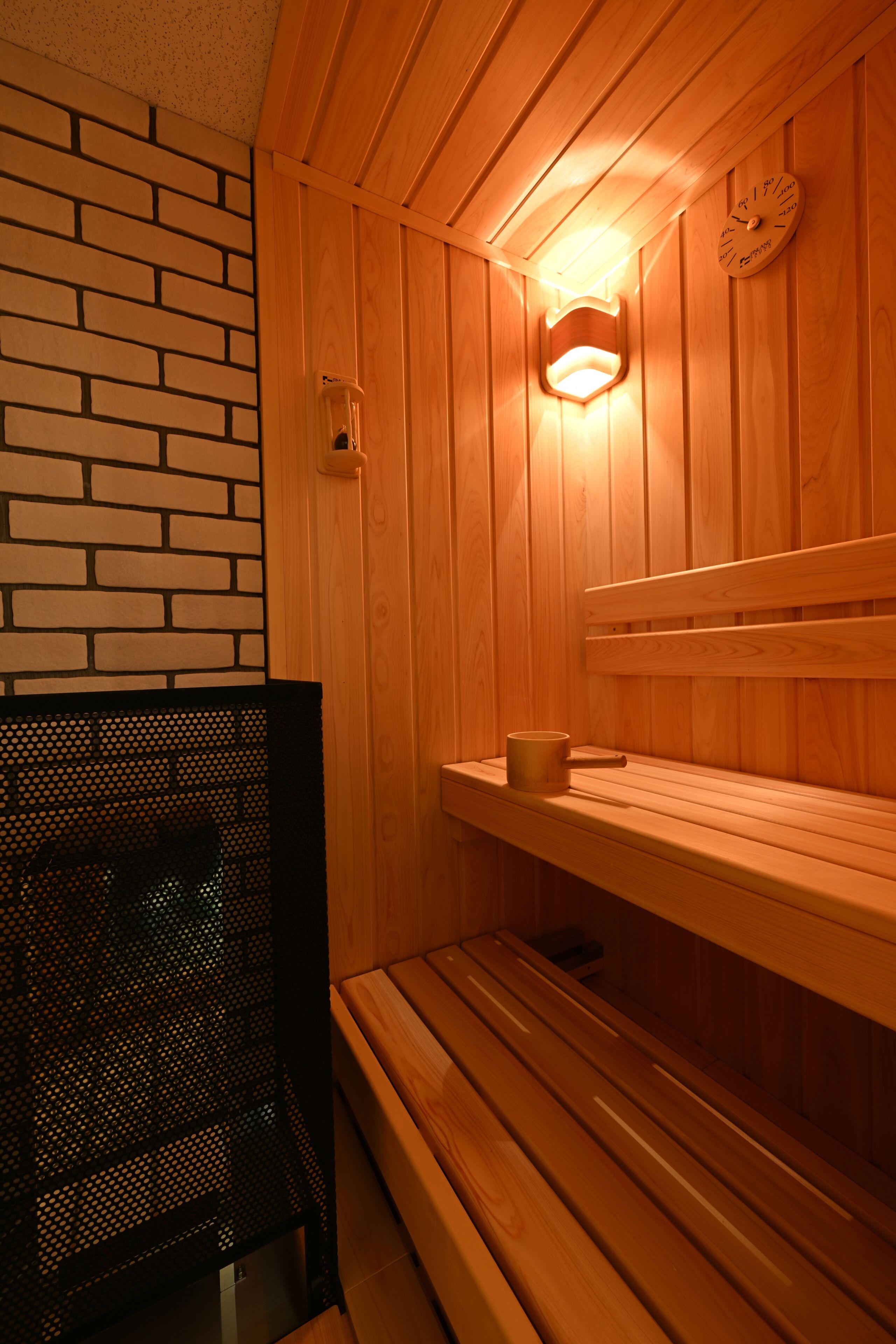 Een houten sauna met banken en een klok aan de muur.