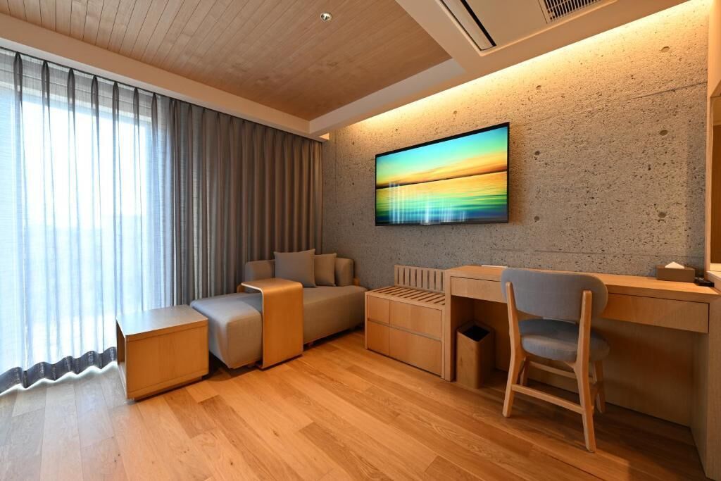 A modern living room with a sofa, a desk, and a chair.