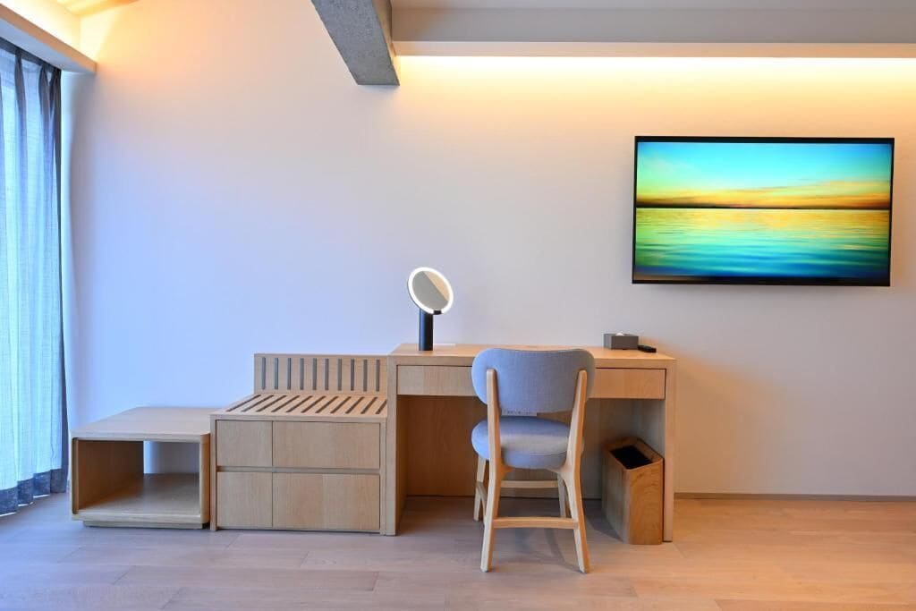 Une chambre moderne équipée d’un bureau, d’une chaise et d’un grand tableau au mur.