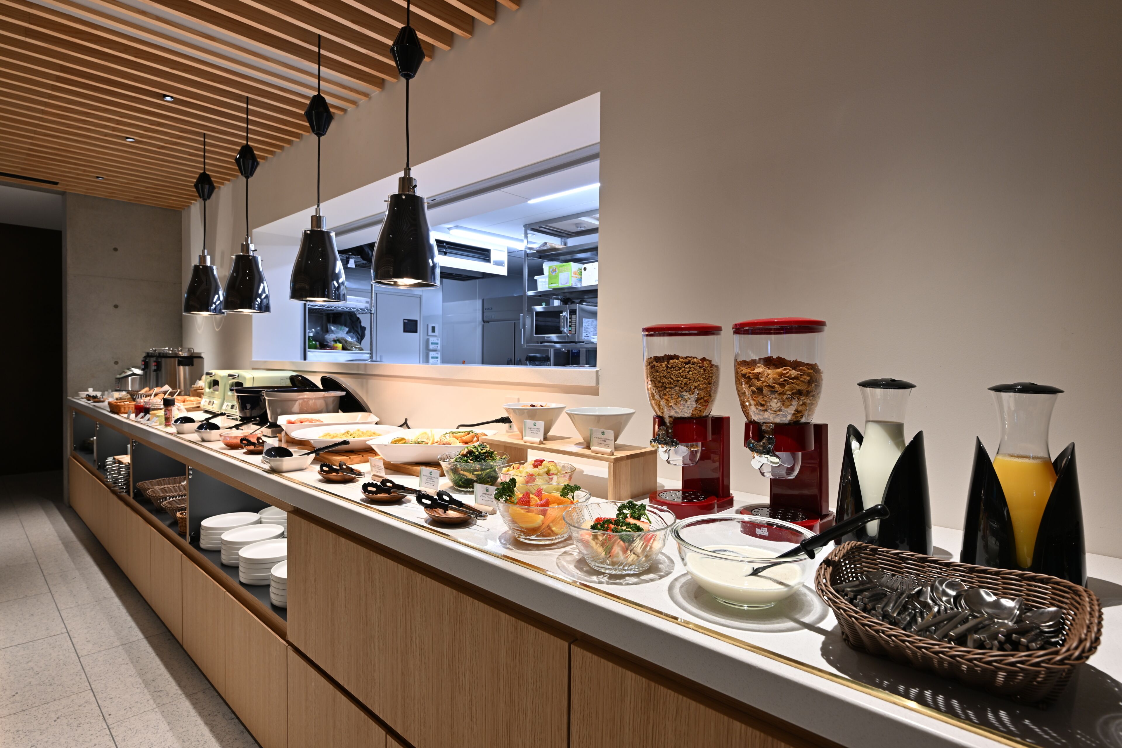 A buffet with various food items, a coffee machine, and beverage dispensers.