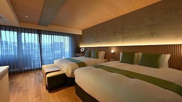 Une chambre d’hôtel avec deux lits, un plafond en bois, une grande fenêtre avec des rideaux et une vue sur la ville.