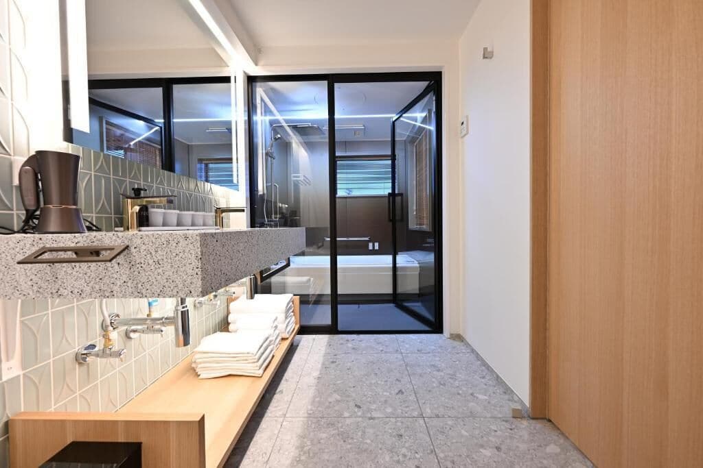 A modern bathroom with a shower, a sink, and a toilet.
