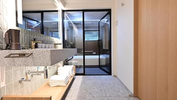 A modern bathroom with a shower, a sink, and a toilet.