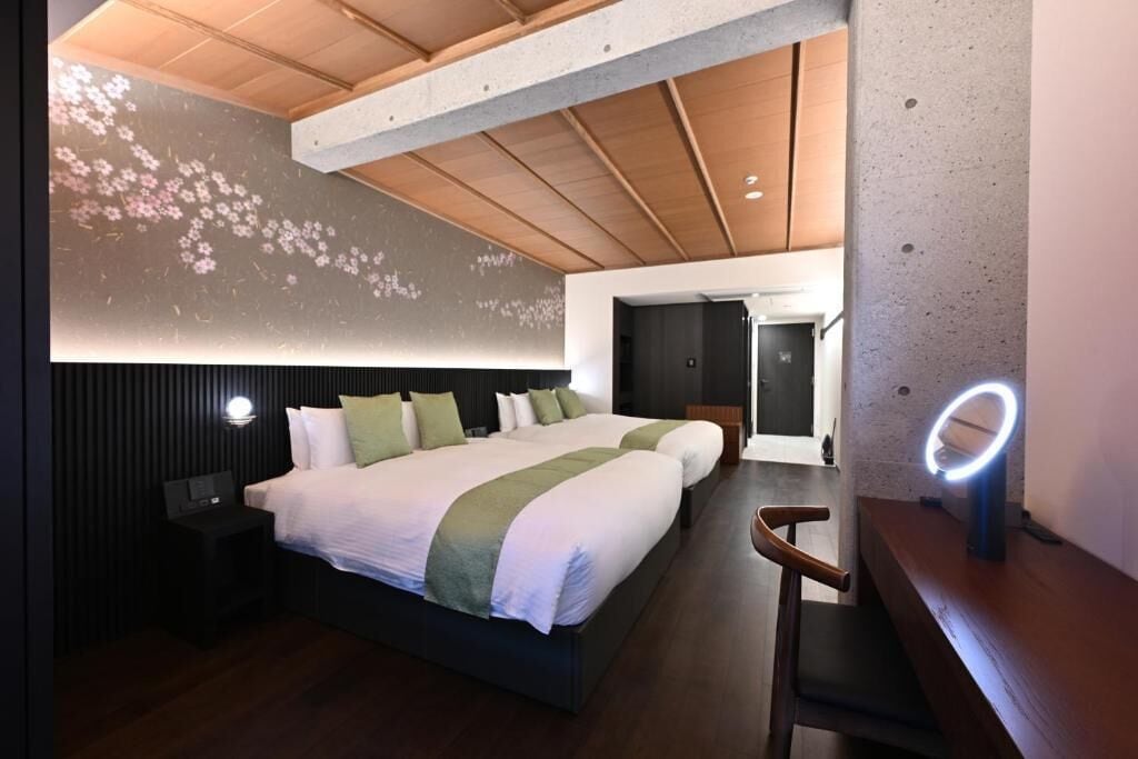 Ein modernes Hotelzimmer mit einem großen Bett, einem Nachttisch, einem Sessel und einer Wandleuchte.