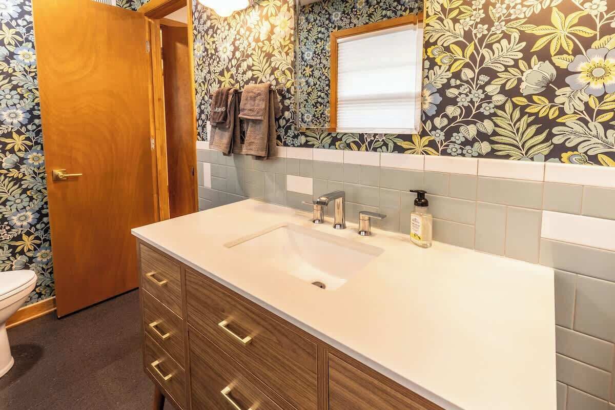 Une salle de bain avec un meuble-lavabo en bois, un évier et un miroir.
