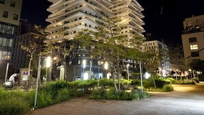 Un edificio de varios pisos con diseño arquitectónico moderno, con balcones e iluminación exterior.