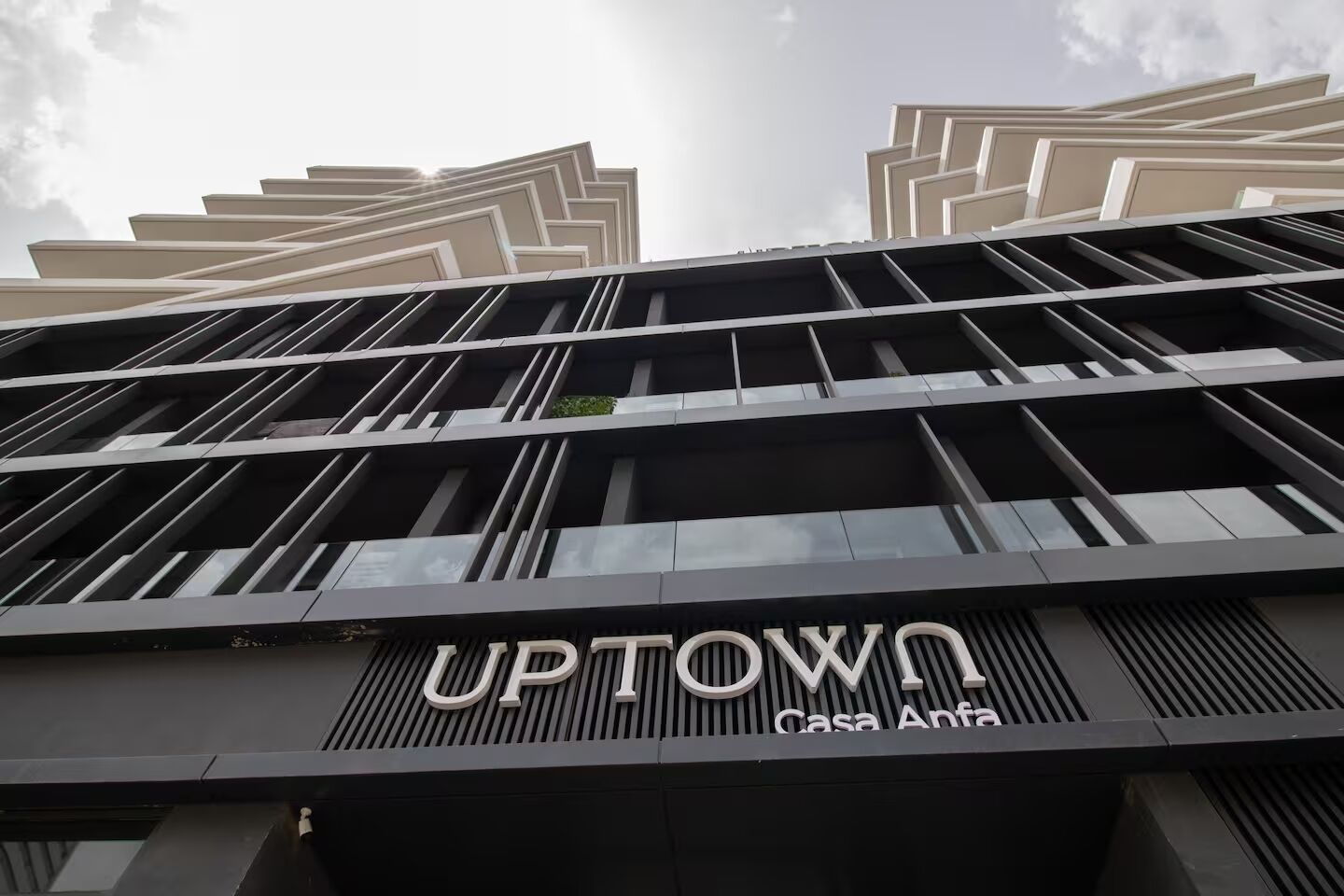 A modern building with the sign "UPTOWN Casa Anfa".