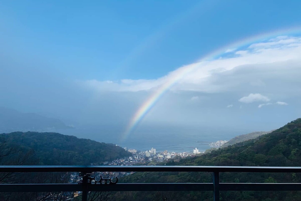 A cityscape with a rainbow over mountains.
