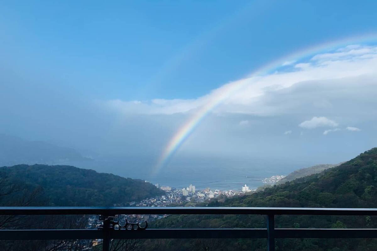 Une vue d’une ville avec un arc-en-ciel au-dessus des montagnes.