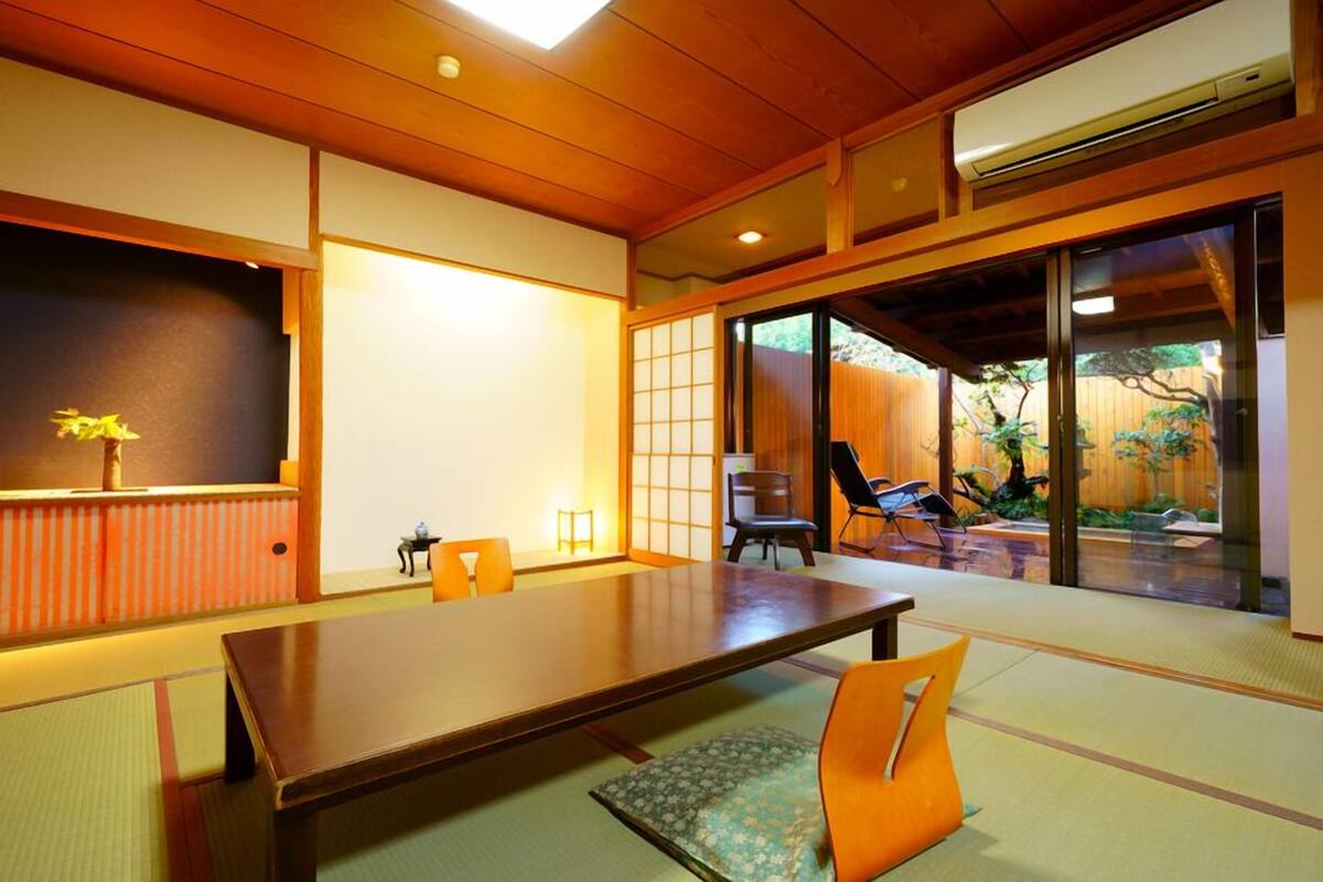 A traditional Japanese-style room with tatami flooring, a low table, and sliding doors.