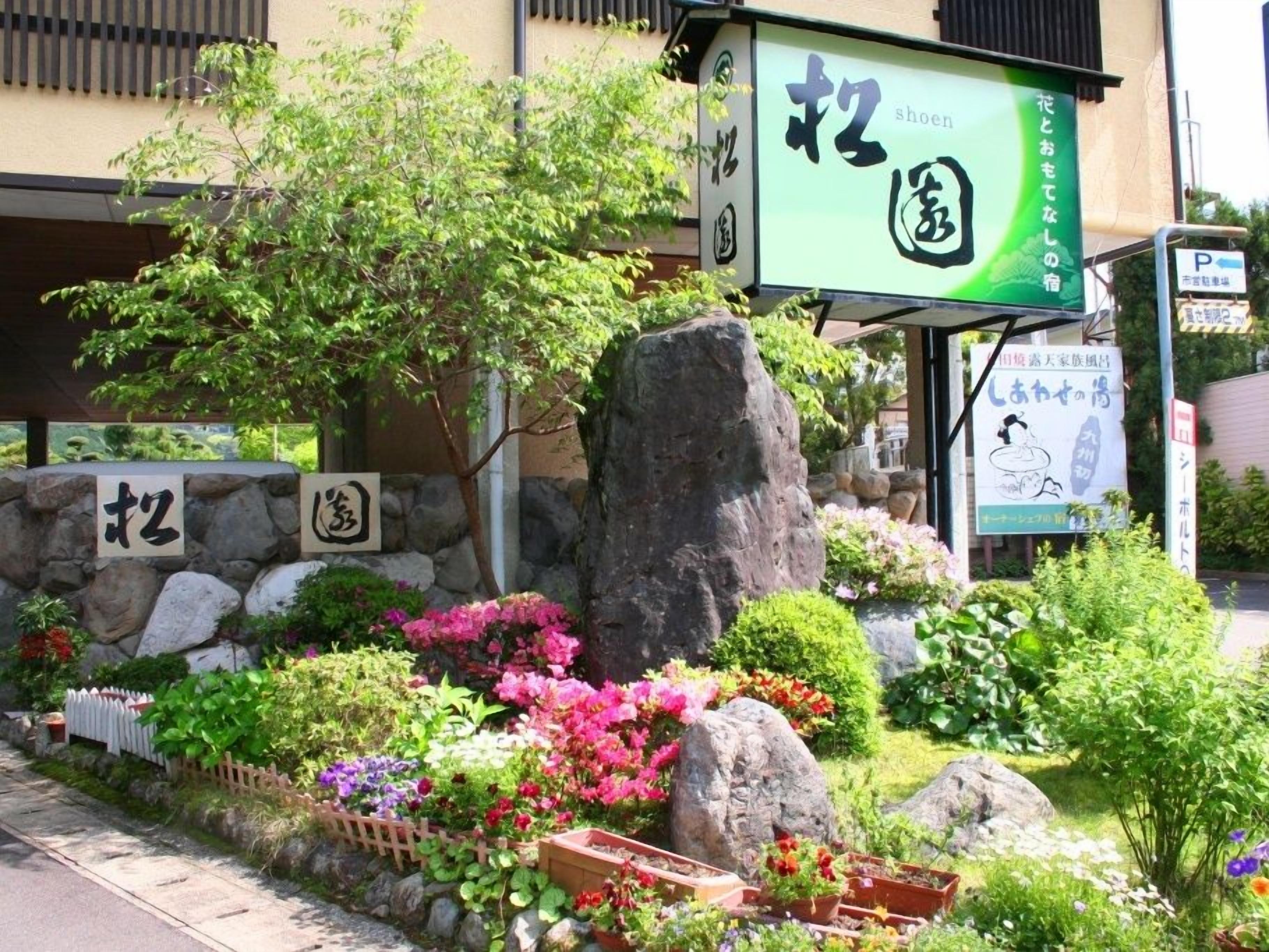 Un restaurante japonés con pared de piedra y plantas en macetas.