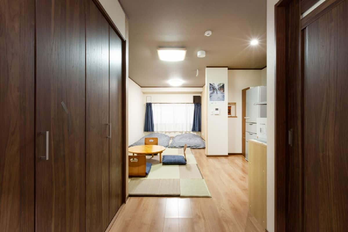 Ein kleines Zimmer mit einem Bett, einem kleinen Tisch und einer Küchenzeile.