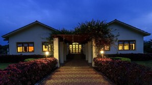 A two-story house with a covered entrance and a paved pathway leading to the front door. - Amã£ Stays & Trails Nine Palms, Alibag (Alibag)