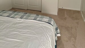 Une chambre à coucher avec un lit, une armoire et une porte.