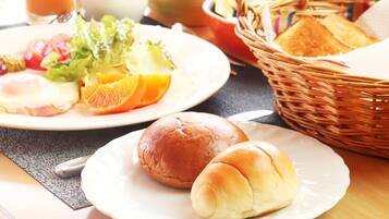 A breakfast setting with a plate of eggs, toast, and fruit, and a basket with bread.