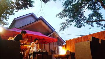 An outdoor patio area with a fire feature, wicker furniture, and a covered seating area.