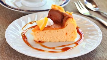 A slice of cake with caramel sauce and a lemon slice on a plate.