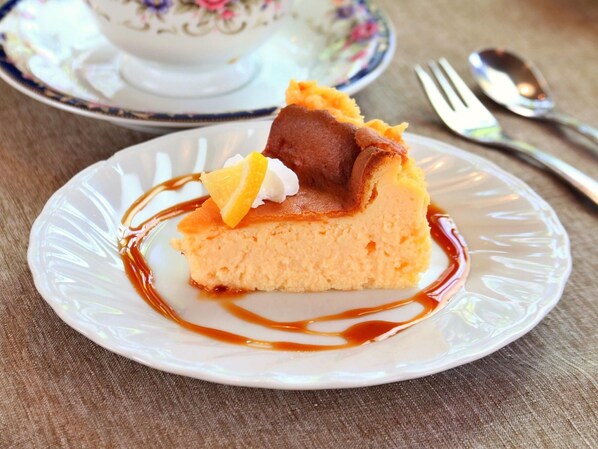 A slice of cake with caramel sauce and a lemon slice on a plate. - Guesthouse Curry Village (Kiryu)
