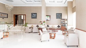 Eine geräumige Lobby mit Treppe, Sitzgelegenheiten und Kunstwerken an den Wänden.