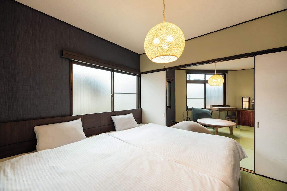A hotel room with a large bed, a desk, and a chair.