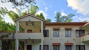 Un edificio de dos pisos con balcones y señalización que indica 'Finch's Charm' y 'Babbler's Brook'.