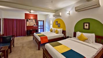 A hotel room with two beds, a desk, and a chair.