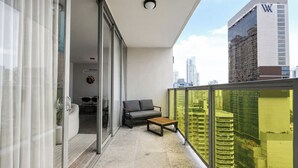 Een balkon met een bank, een bijzettafeltje en een schuifdeur die leidt naar een eethoek.