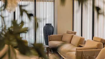 A modern living room with a beige sectional sofa, a small table, and a large vase.