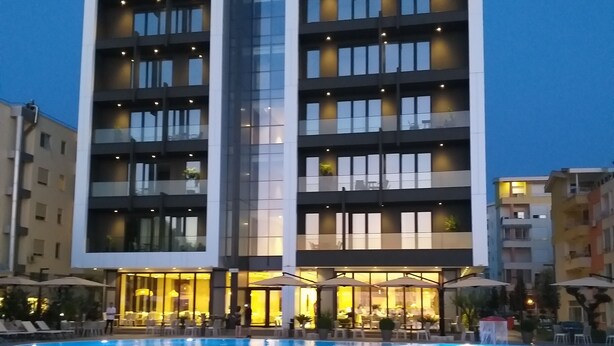 Un hôtel moderne doté d’une piscine, de nombreux balcons et d’espaces extérieurs aménagés pour se détendre.
