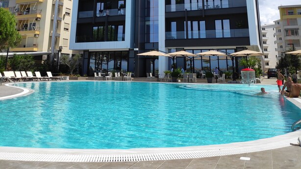 A modern building with a swimming pool in front. - Supreme Hotel (Golem)