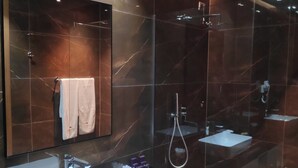Casa de banho moderna com duas lavatórios, um espelho grande e um chuveiro.