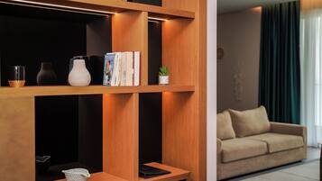 A modern living room with wooden shelves, a beige sofa, and a small potted plant.