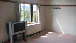 A room with a window, a radiator, and a television on a stand. - Sports Pal (Inawashiro)