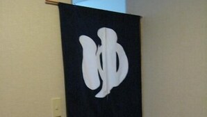 A hallway with a black banner featuring a white logo. - Sports Pal (Inawashiro)