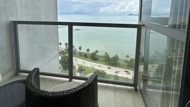 Un balcon avec vue sur la mer et une route.