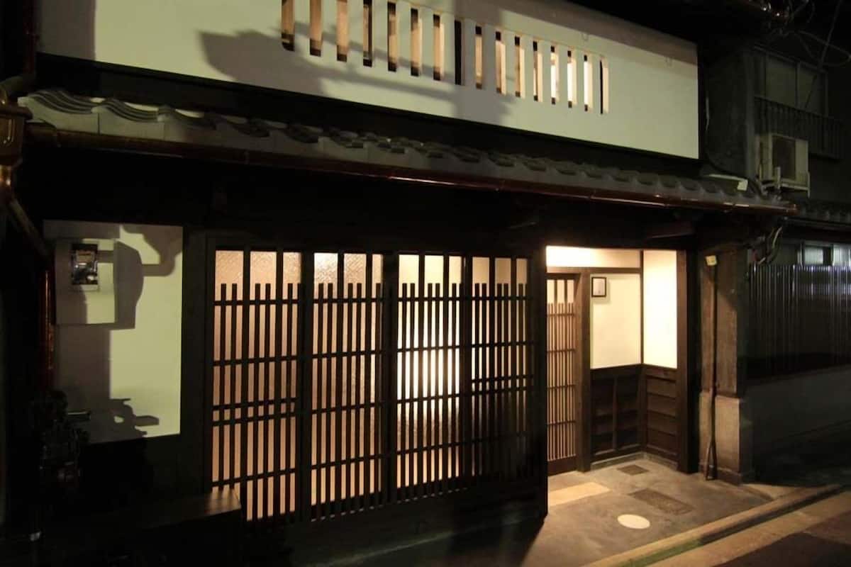 A traditional Japanese building with a wooden gate, a small entrance, and a tiled roof.