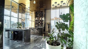 A modern kitchen with a marble countertop, bar stools, and a large window overlooking a cityscape. - Exclusive and Luxurious 2BR at Wanders and Yoo (Panama City)