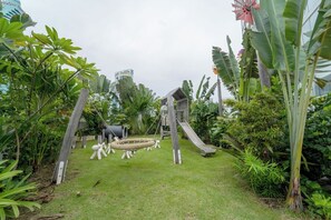 A playground with a rope swing, a slide, and a small wooden house structure. - Exclusive and Luxurious 2BR at Wanders and Yoo (Panama City)