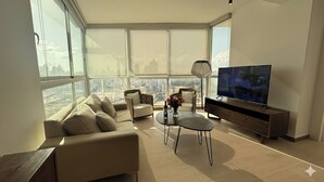 Uma sala de estar moderna com um sofá, uma mesa de centro e uma televisão.