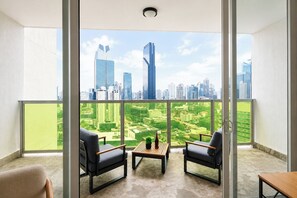 A balcony with two chairs, a small table, and a city view. - Exclusive and cozy 1BR balcony in Yoo Panama (Panamá)