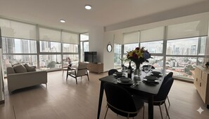 A modern apartment with a dining area, a living room, and a TV. - Stunning 3BR with Views, Balcony and Parking (Panamá)