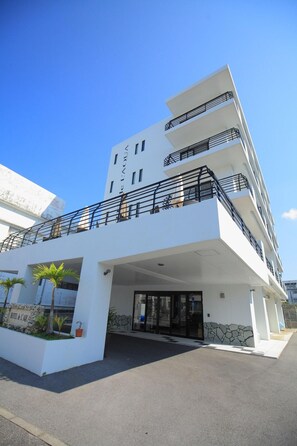 A modern hotel with a white facade, multiple balconies, and a stone facade entrance. - Hotel De L Aqua (Miyakojima)