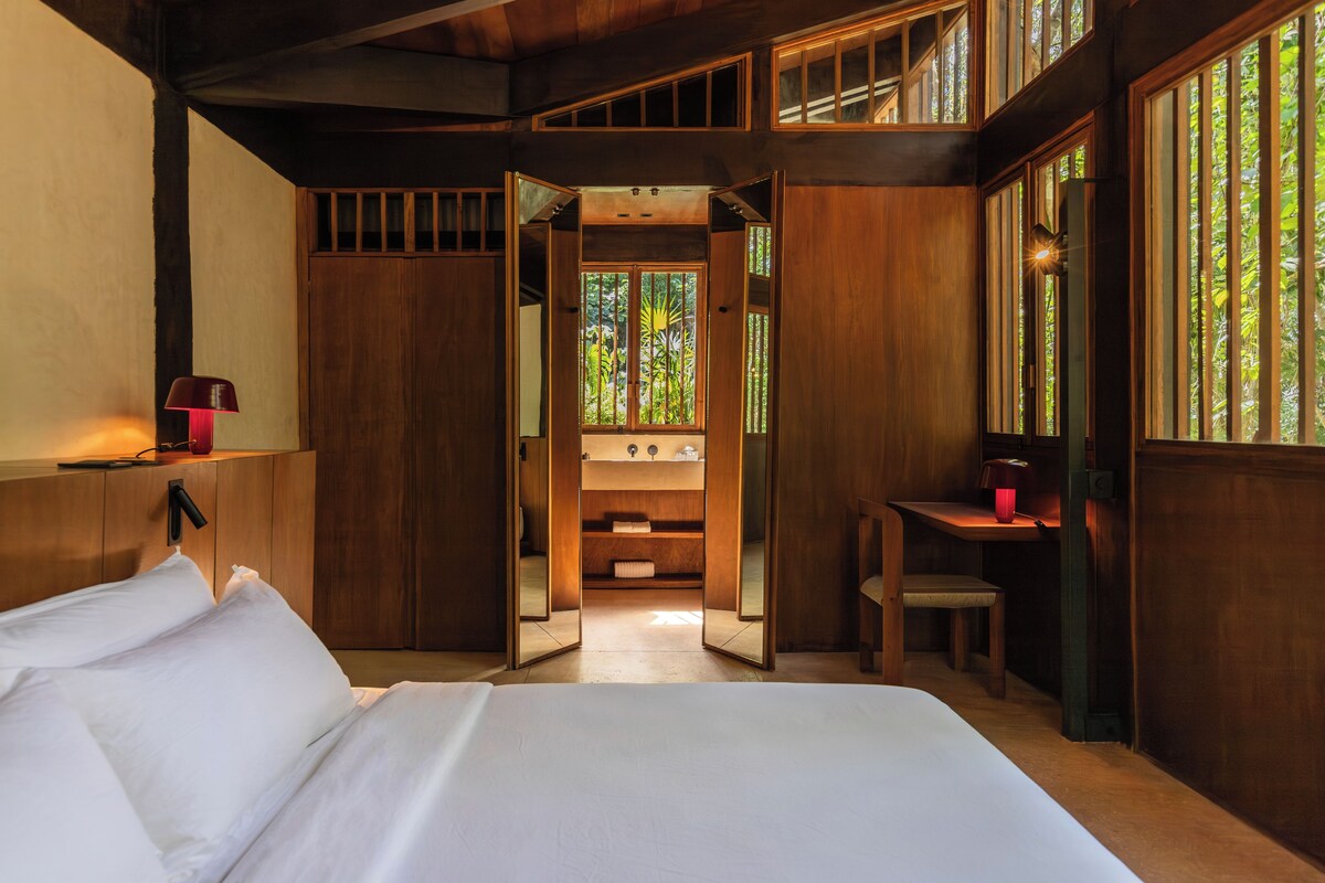 Ein Schlafzimmer mit Bett, Schreibtisch und angrenzendem Badezimmer.