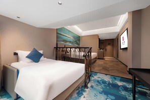 Une chambre d’hôtel avec un lit, un bureau, une salle de bain et une vue sur la ville.