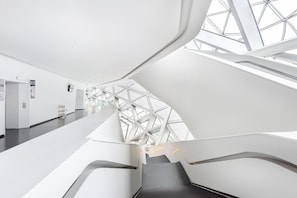 A modern architectural interior with a central staircase and a glass ceiling. - Echerm Hotel Wuyangcun Metro Station (Guangzhou)
