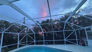 Une piscine avec vue sur les palmiers et un ciel dégagé.