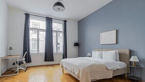 A bedroom with a bed, a desk, and a chair. - Blueground | Innere Stadt, balcony, nr St. Stephen's Cathedral (Vienna)