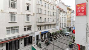 A street view of a building with multiple floors, featuring a restaurant with outdoor seating. - Blueground | Innere Stadt, balcony, nr St. Stephen's Cathedral (Vienna)