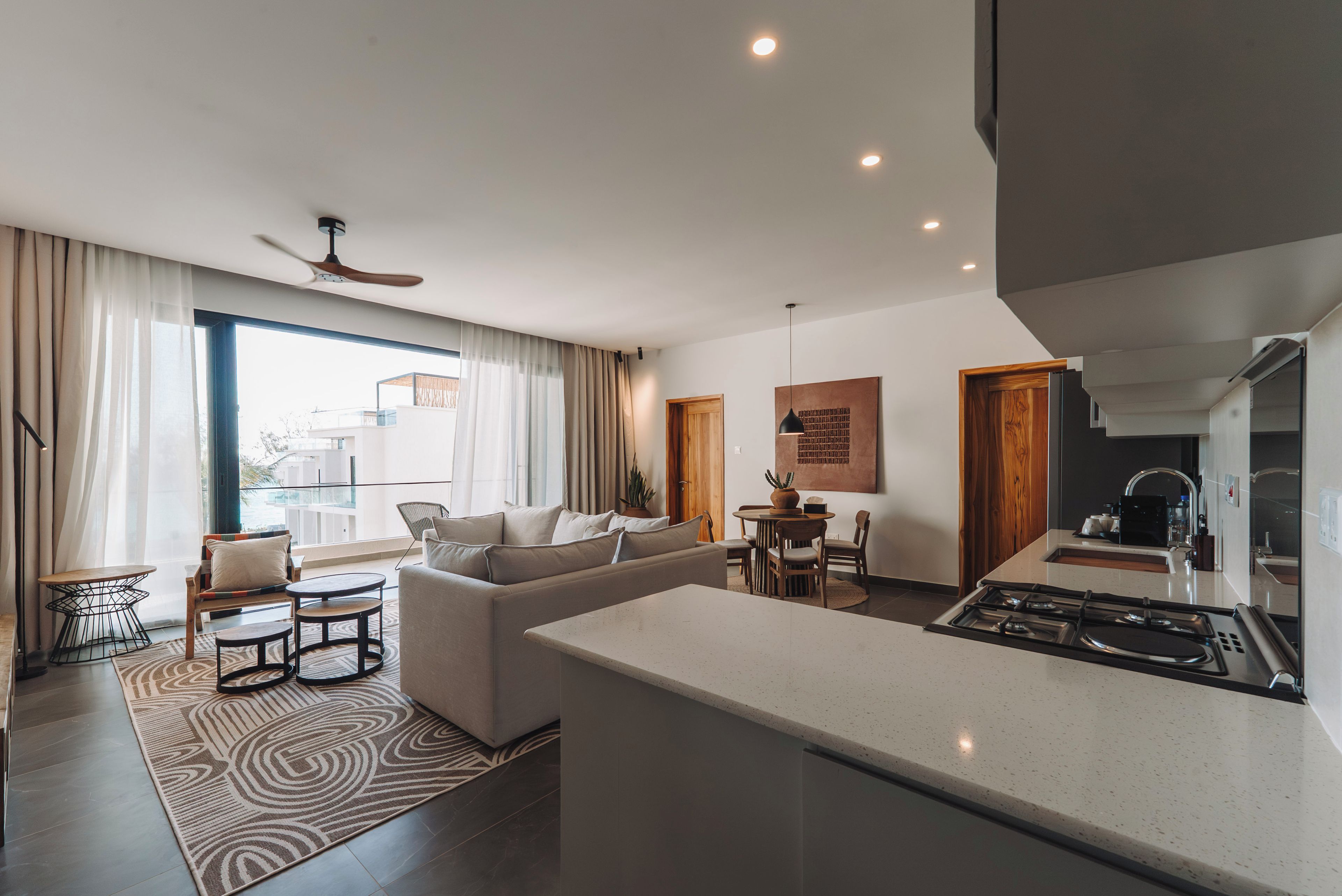 A modern living room with a sofa, coffee table, and dining area.