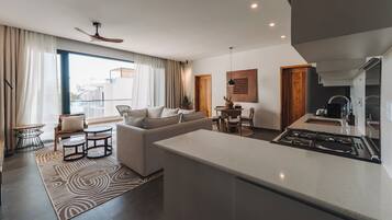 A modern living room with a sofa, coffee table, and dining area.